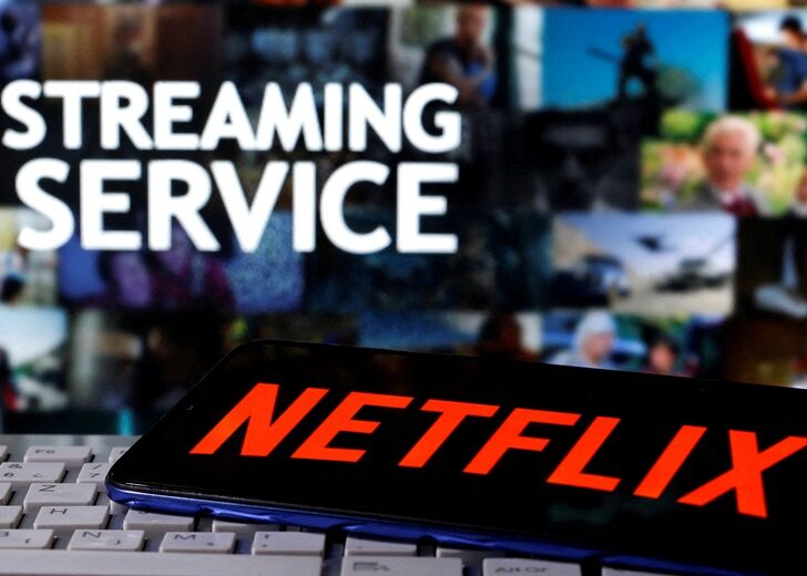 FILE PHOTO: FILE PHOTO: A smartphone with the Netflix logo is seen on a keyboard in front of displayed