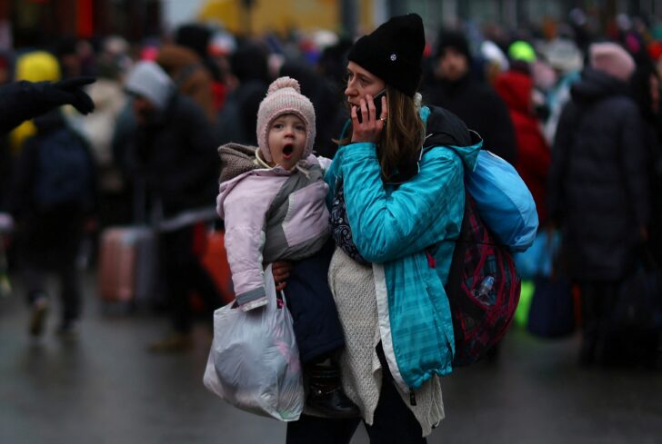 Refugees wait for their transfer to Poland at the train station in Lviv