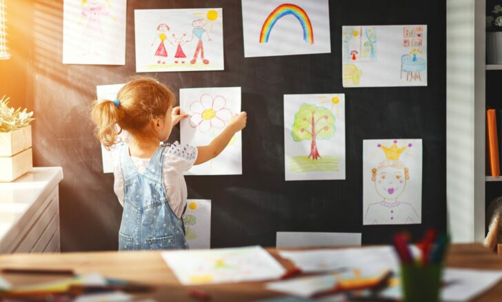 Child,Girl,Hanging,Her,Drawings,On,The,Wall