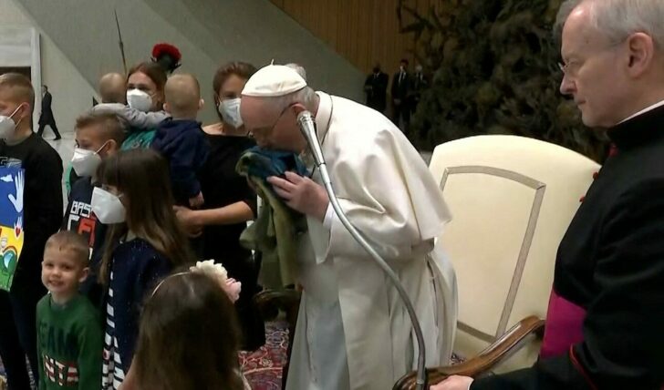 Pope Francis kisses the Ukrainian flag