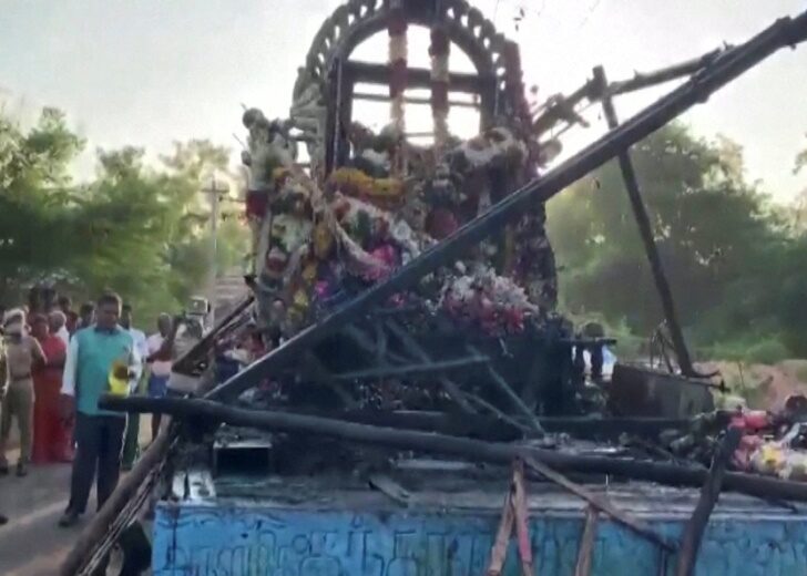 People gather around a chariot that was damaged after a high voltage power wire fell on it, killing at least 11 people, during a procession in a temple festival in Kalimedu village