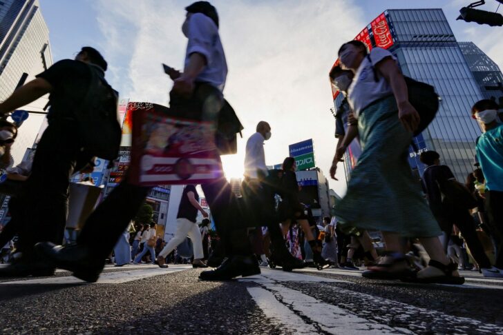Passersby wearing protective face masks walk on the Shibuya crossing, amid the coronavirus disease (COVID-19) pandemic, in Tokyo