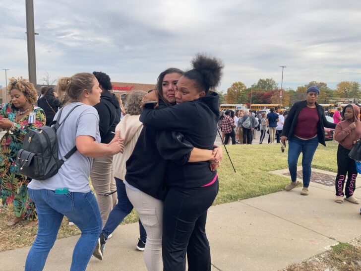 People embrace following a shooting at a high school, in St. Louis