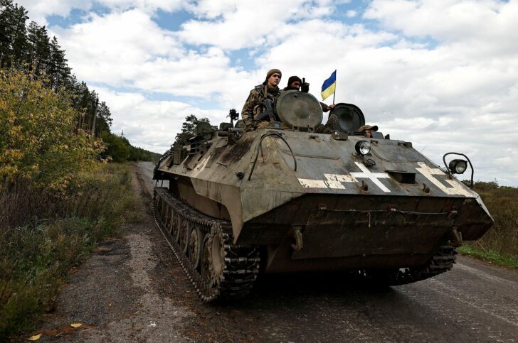 FILE PHOTO: Ukrainians ride an armoured vehicle in Donesk region