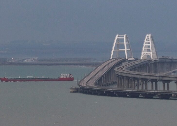 A cargo ship sails next to the Kerch bridge, after an explosion destroyed part of it, in the Kerch Strait, Crimea