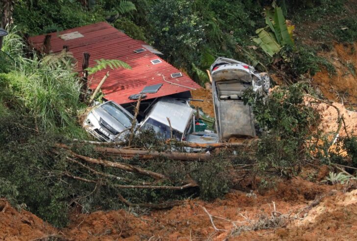 Damaged cars are seen amongst the debris during a rescue and evacuation operation following a landslide at a campsite in Batang Kali