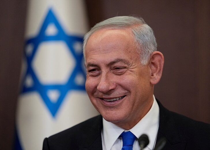 Newly sworn in Israeli Prime Minister Benjamin Netanyahu smiles during a cabinet meeting in Jerusalem