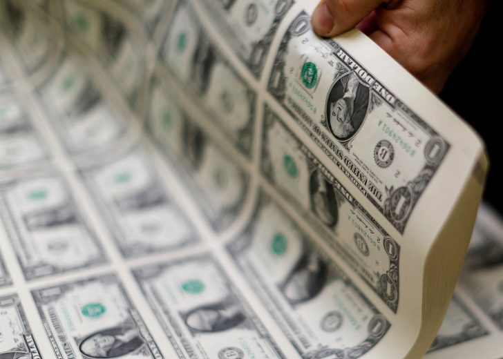 FILE PHOTO: United States one dollar bills are curled and inspected during production at the Bureau of Engraving and Printing in Washington