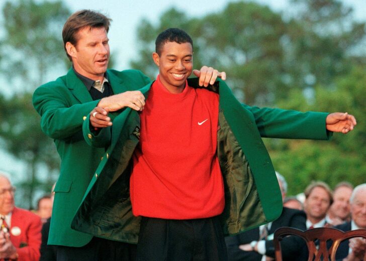 FILE PHOTO: Tiger Woods of the U.S. is given the victor's green jacket after winning the Masters golf tournament in Augusta