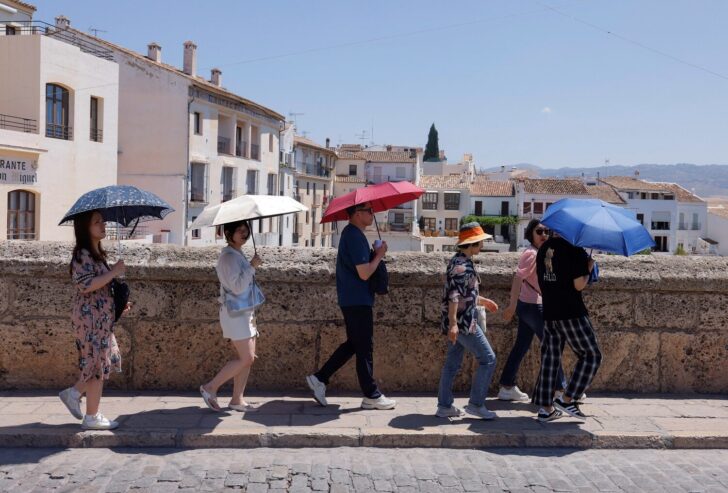 Tourists tour along the Puente Nuevo (New Bridge) on a hot summer day in Ronda