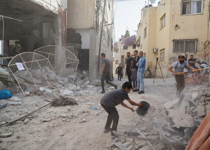 Palestinians remove rubble from a mosque which was hit in an Israeli air strike, in Jenin