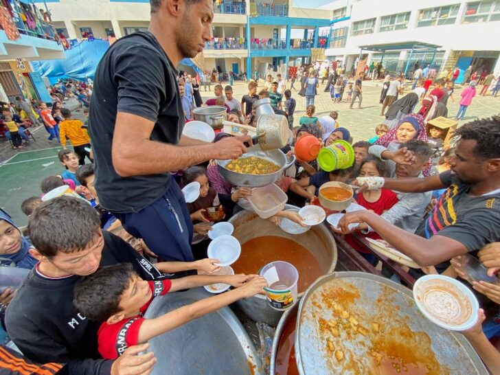 FILE PHOTO: Palestinians, who fled their houses due to Israeli strikes, gather to get their share of charity food, in Rafah