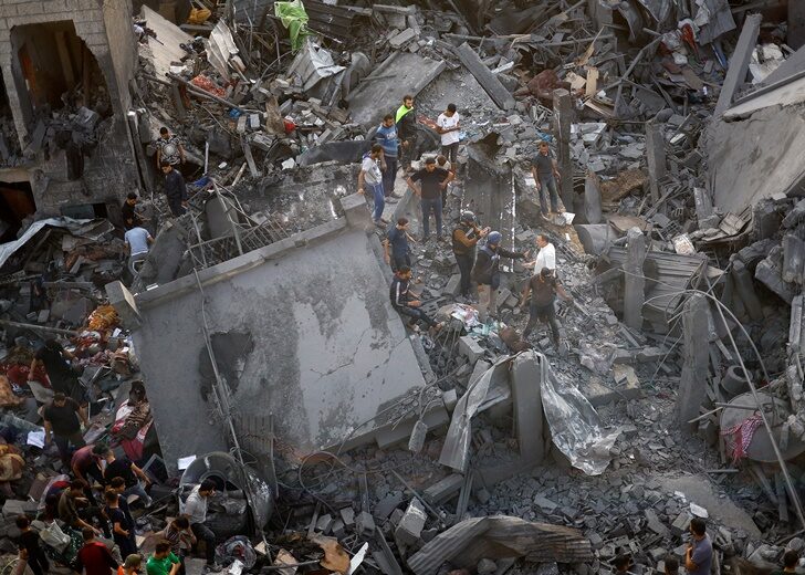 Palestinians search for casualties at the site of Israeli strikes on houses, at the Magazi Refugee Camp