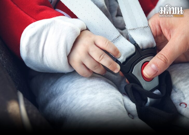 Mom fastens a safety belt in the car seat in which her little ch