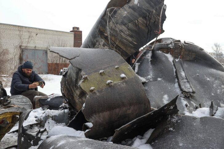 A man photographs parts of an unidentified missile, which Ukrainian authorities believe to be made in North Korea, in Kharkiv