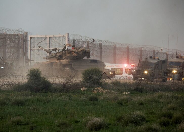 A tank manoeuvres along the Israel-Gaza border fence