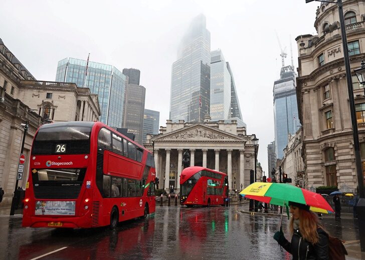 FILE PHOTO: Commuters walk in City of London financial district in London