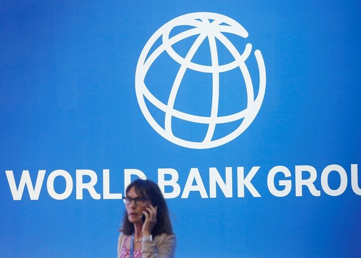 FILE PHOTO: A participant stands near a logo of World Bank at the International Monetary Fund - World Bank Annual Meeting 2018 in Nusa Dua