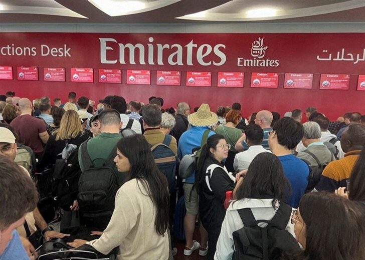 FILE PHOTO: People queue at a flight connection desk after a rainstorm hit Dubai, causing delays at the Dubai International Airport