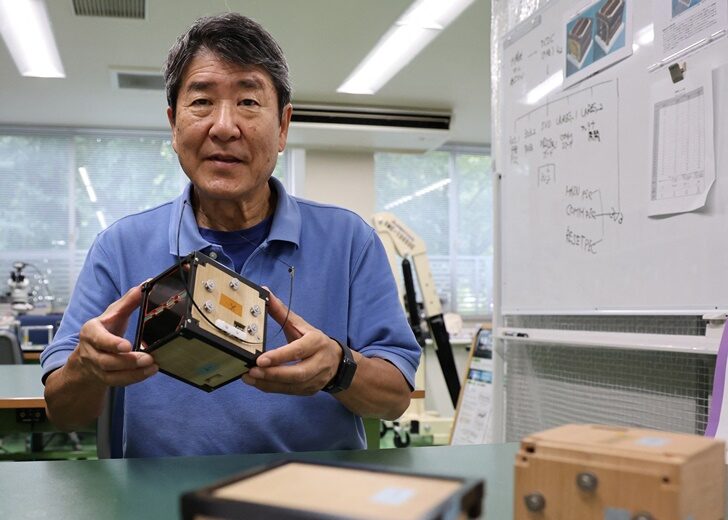 Takao Doi holds an engineering model of LignoSat during an interview with Reuters at his laboratory at Kyoto University in Kyoto
