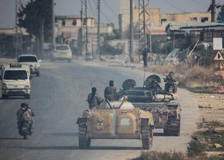 Rebels led by the Islamist militant group Hayat Tahrir al-Sham drive along a street in al-Rashideen, Aleppo province