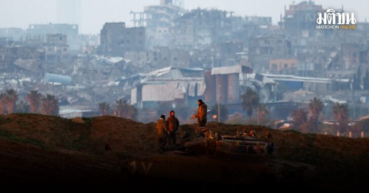Soldiers stand on top of a tank on the Israeli side at the border with Gaza
