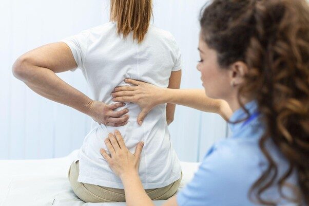แพทย์กำลังตรวจและรักษาอาการปวดหลังของผู้ป่วย