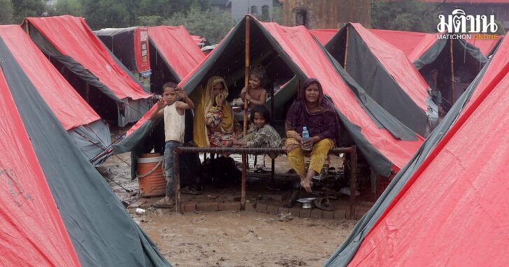 Members of a family, who fled from flooded banks of Ravi River, take shelter in a tent at a relief camp in Lahore