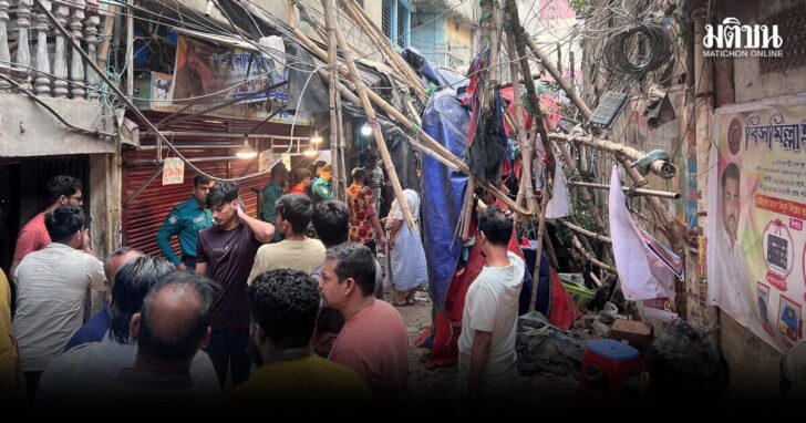 Residents stand in an alley after vacating their house next to a fallen scaffolding following an earthquake in Dhaka