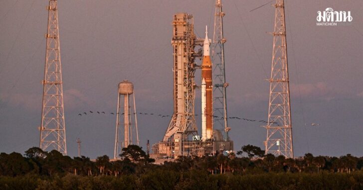 A flock of birds flies by the Space Launch System (SLS), with the Orion crew capsule, at launch complex 39B