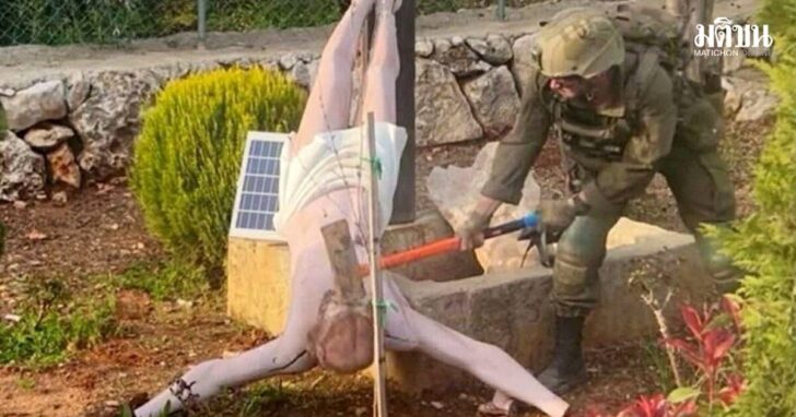 FILE PHOTO: An Israeli soldier damages the head of a statue of Jesus, in Debel