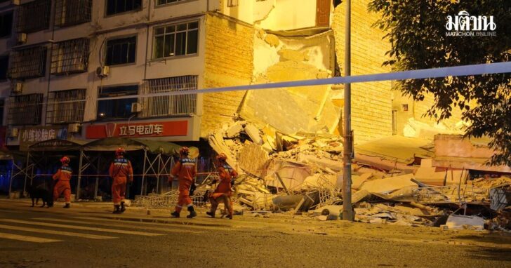 Rescue workers walk past a damaged building following an earthquake in Liuzhou