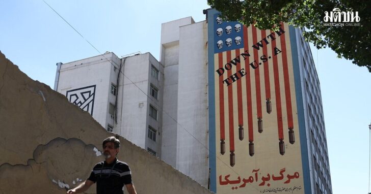 A man walks past an anti-U.S. mural on a building in Tehran