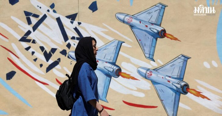An Iranian woman walks next to an anti-Israeli mural on a street in Tehran