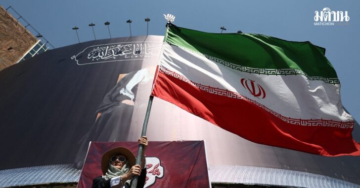 A woman holds an Iranian flag on a street in Tehran