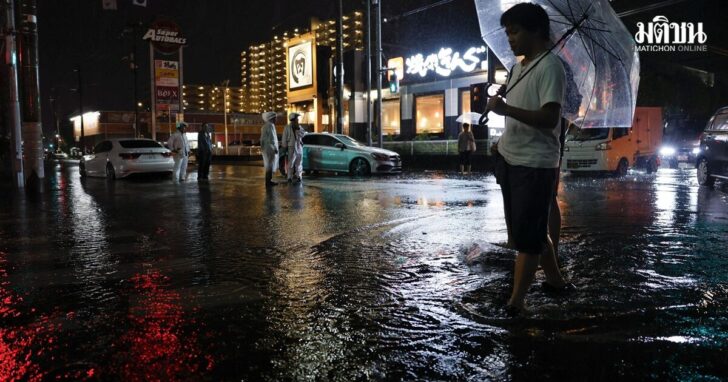 A man walks on a flooded road after torrential rain in Ichikawa