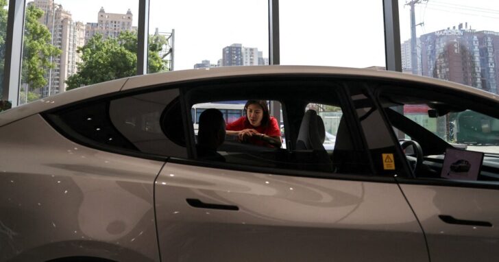 FILE PHOTO: Staff member attends to a customer inside a Tesla store at a shopping mall in Beijing