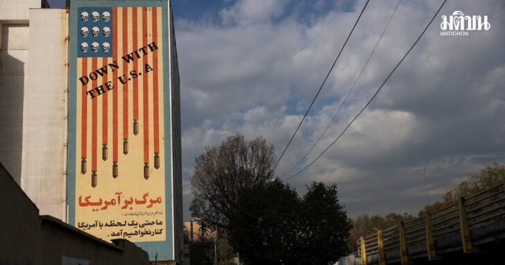 People walk near an anti-US mural in Tehran